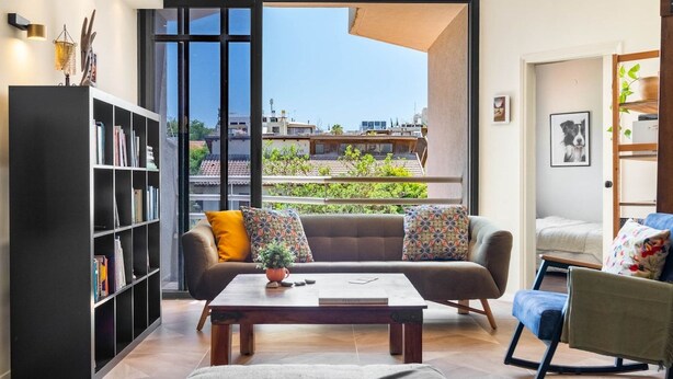 Una sala de estar moderna con un sofá, una mesa de centro y una estantería.
