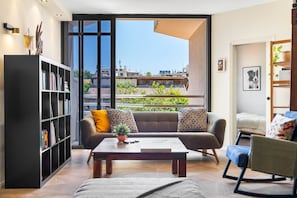 A modern living room with a sofa, a coffee table, and a bookshelf.