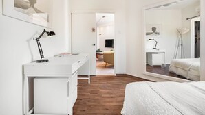 Un dormitorio con una cama, un escritorio, una silla y un espejo.