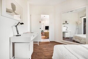 Una camera da letto con un letto, una scrivania, una sedia e uno specchio.