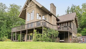 Ein großes, zweistöckiges Holzhaus mit Balkon und Schornstein.