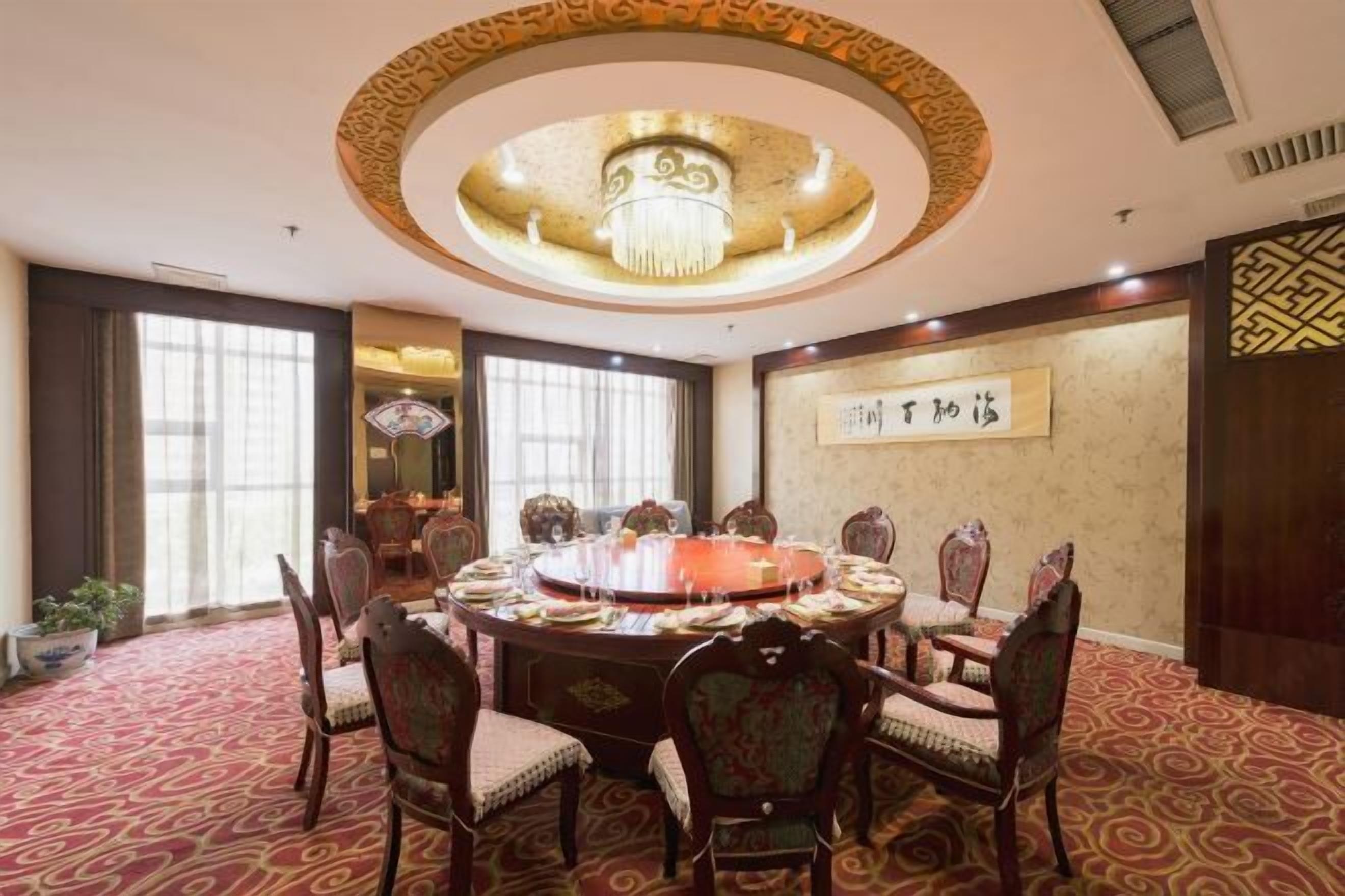 A conference room with a round table, chairs, and a chandelier.