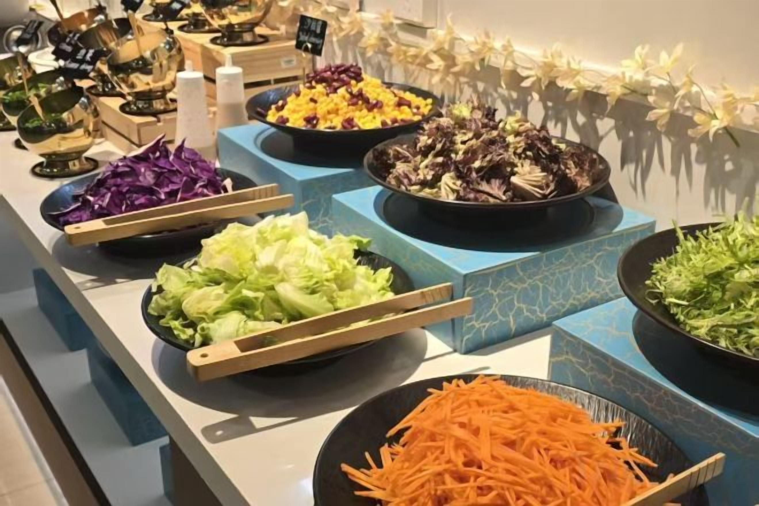 A buffet with various dishes including salads and vegetables.
