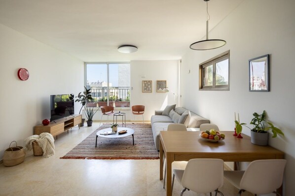 Una sala moderna con sofá, mesa de centro y comedor.