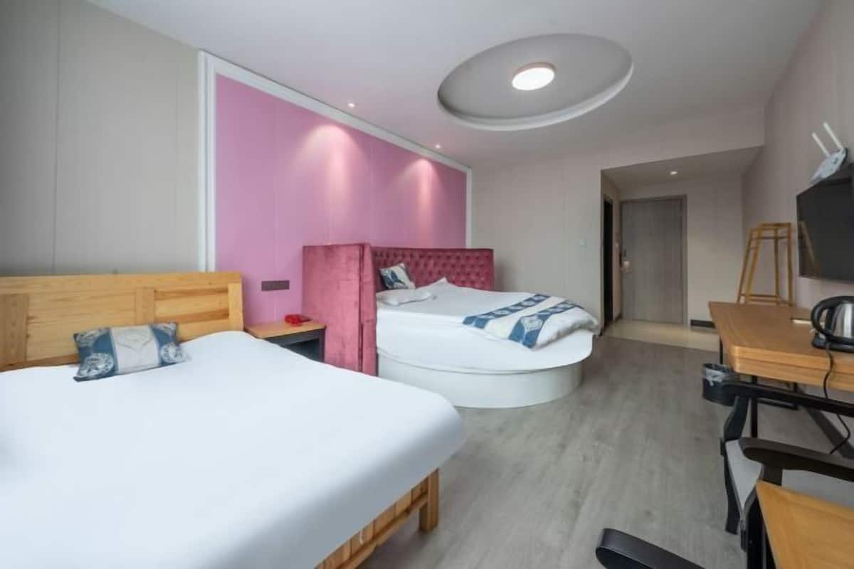 Une chambre d’hôtel moderne équipée de deux lits, d’un bureau et d’une télévision.