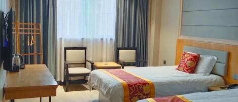 Una habitación de hotel con dos camas, un escritorio, una silla y un televisor.