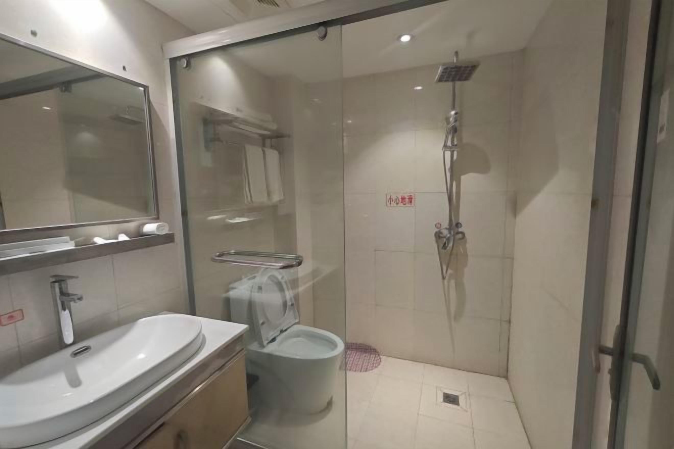 A modern bathroom with a glass shower enclosure, a sink, and a toilet.
