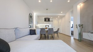 Una sala de estar moderna con sofá, mesa de comedor y sillas.