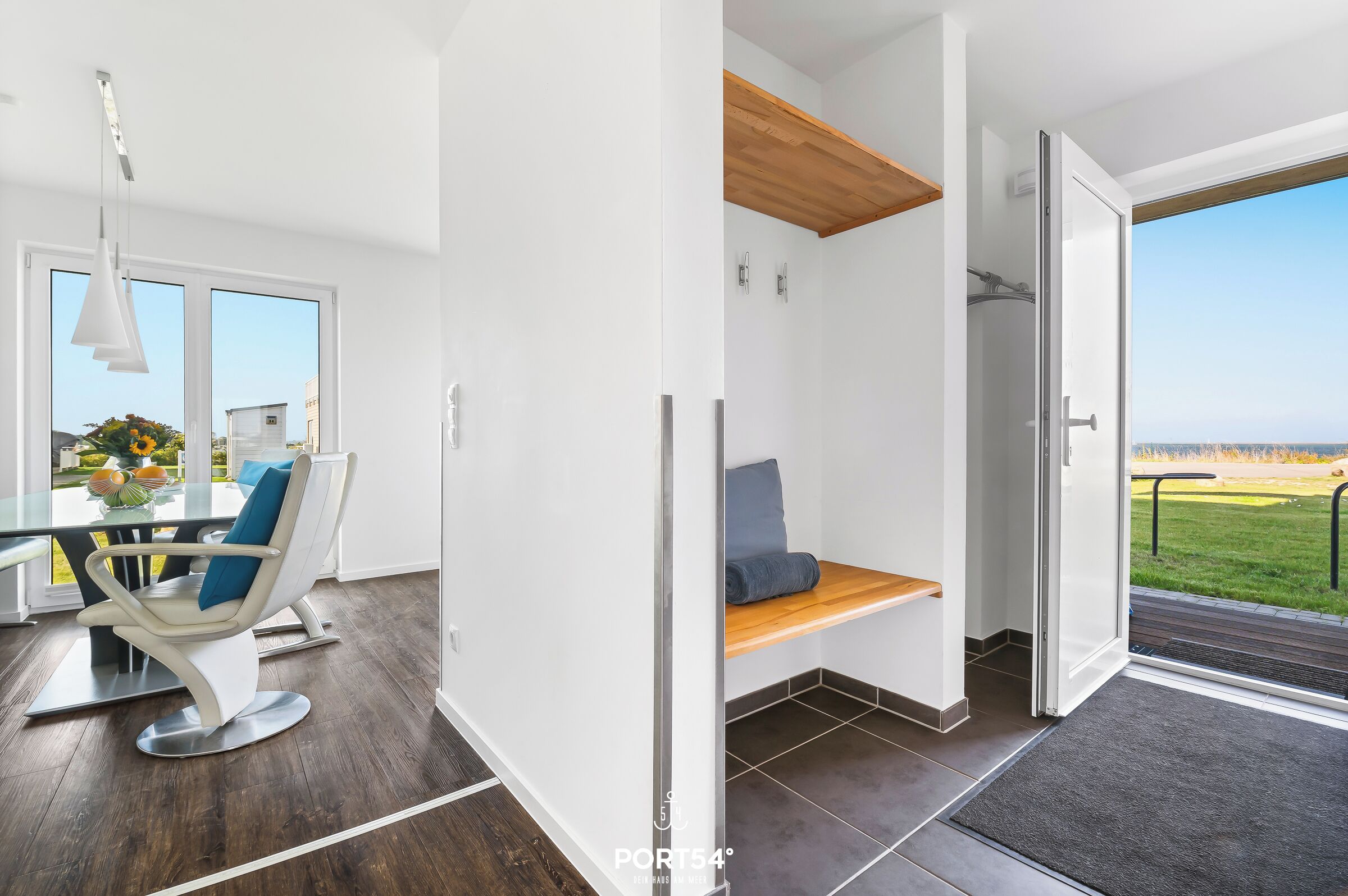 Un interior moderno con comedor, un banco con vistas y una puerta que da a un espacio exterior.