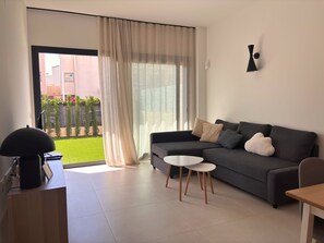 Una sala moderna con un sofá, una mesita y una lámpara.