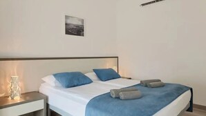Un dormitorio moderno con cama, mesitas de noche y un cuadro colgado en la pared.