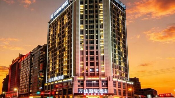 Ein Hochhaus-Hotel mit mehreren Etagen, beleuchteter Beschilderung und einer gut sichtbaren Marke an der Spitze.