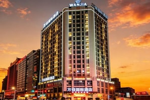 Un hotel moderno de altura con múltiples pisos y llamativa señalización.