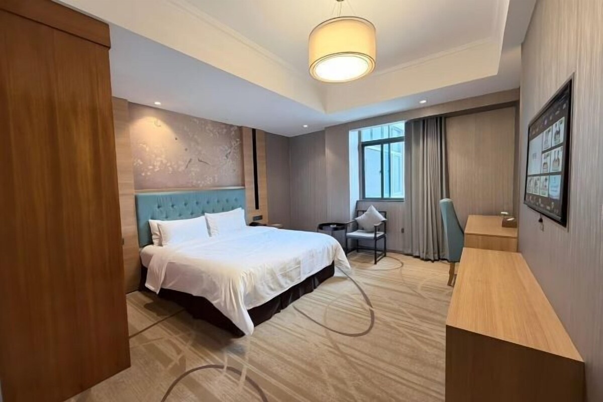 Habitación de hotel con una cama grande, un escritorio y una silla.