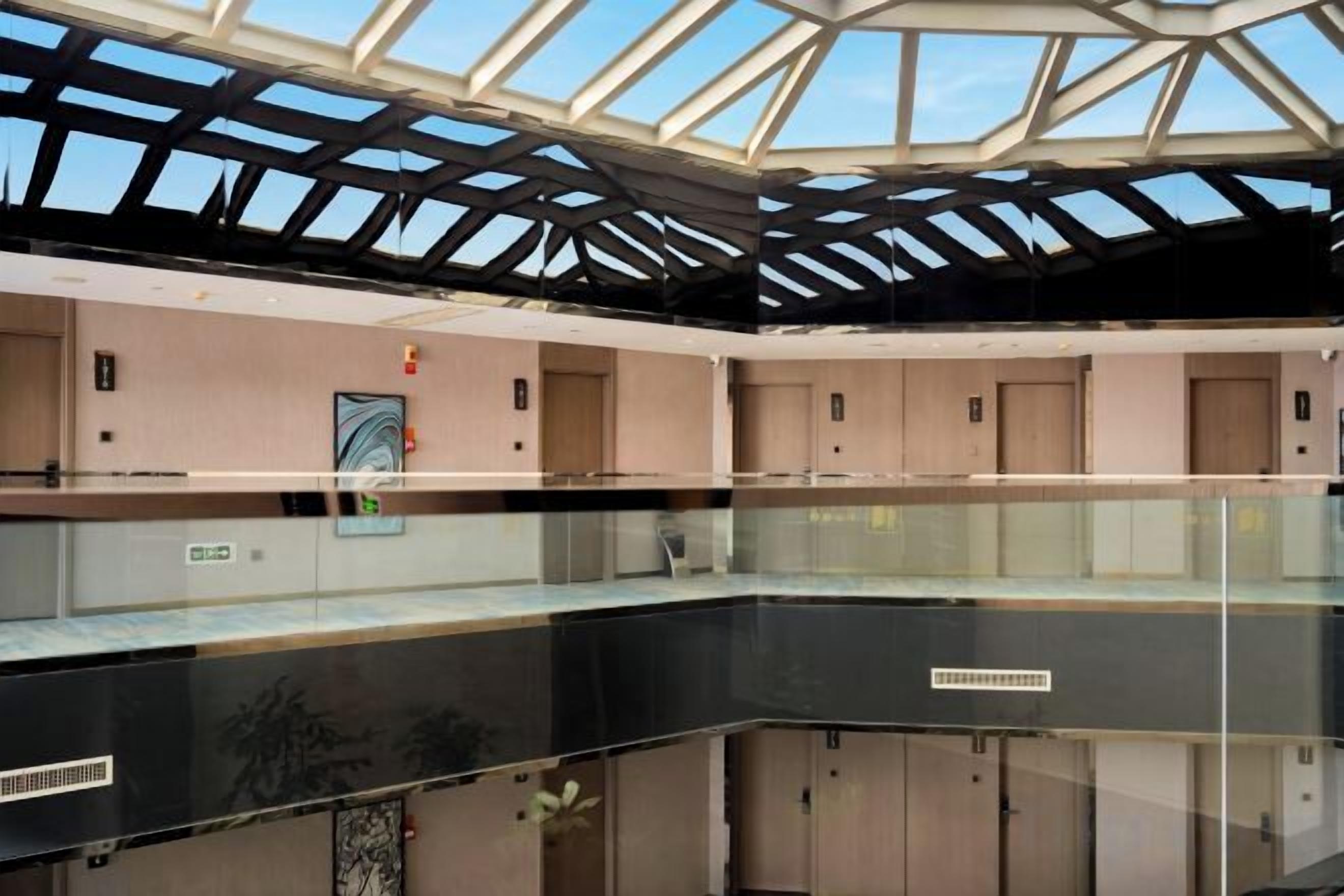 A multi-level atrium with glass railings, a skylight, and a central staircase.
