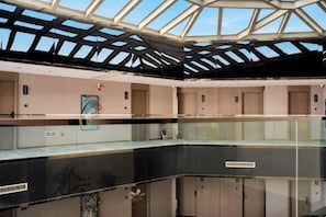A multi-level atrium with glass railings, a skylight, and a central staircase.