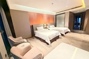 Habitación de hotel con dos camas, una silla de masajes y un espejo grande.