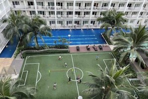Un hôtel doté d’une piscine, d’un court de tennis et de palmiers.