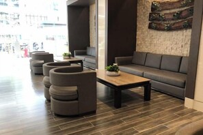 Ein stilvoller Aufenthaltsbereich mit einer Couch, Sesseln und einem Couchtisch.