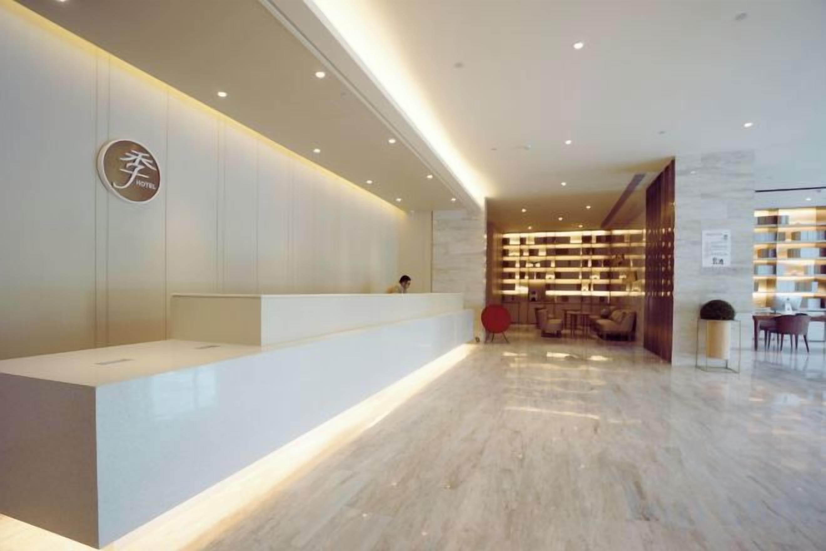 A reception area with a reception desk, seating area, and a bookshelf.