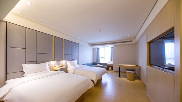 A hotel room with two beds, a desk, a TV, and a large window. - Ji Hotel (Jiaxing)