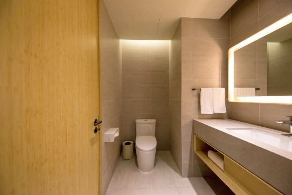 Une salle de bain moderne équipée de toilettes, d’un lavabo et d’un miroir.