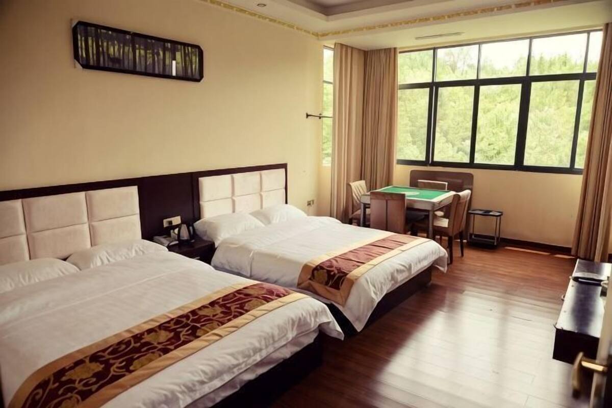 Una habitación de hotel con dos camas, un escritorio y una silla.