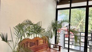 A wooden bench with a bench seat and backrest, flanked by two potted plants.