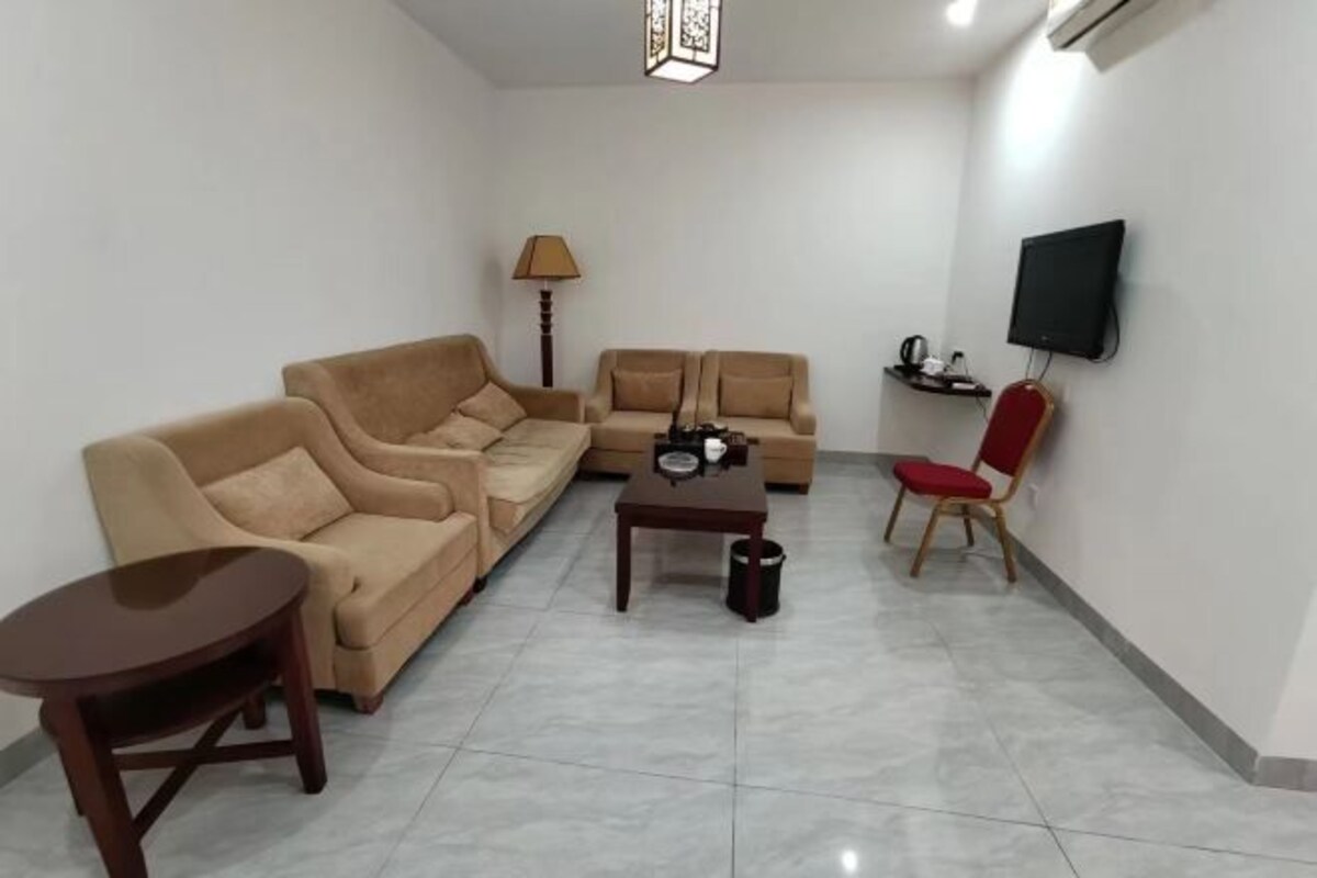 A living room with two sofas, a coffee table, a TV, and a lamp.