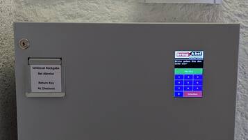 A hotel room's entry system with a keypad and a sign above it.