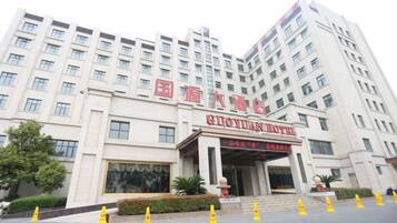 A multi-story hotel building with a prominent entrance and signage.