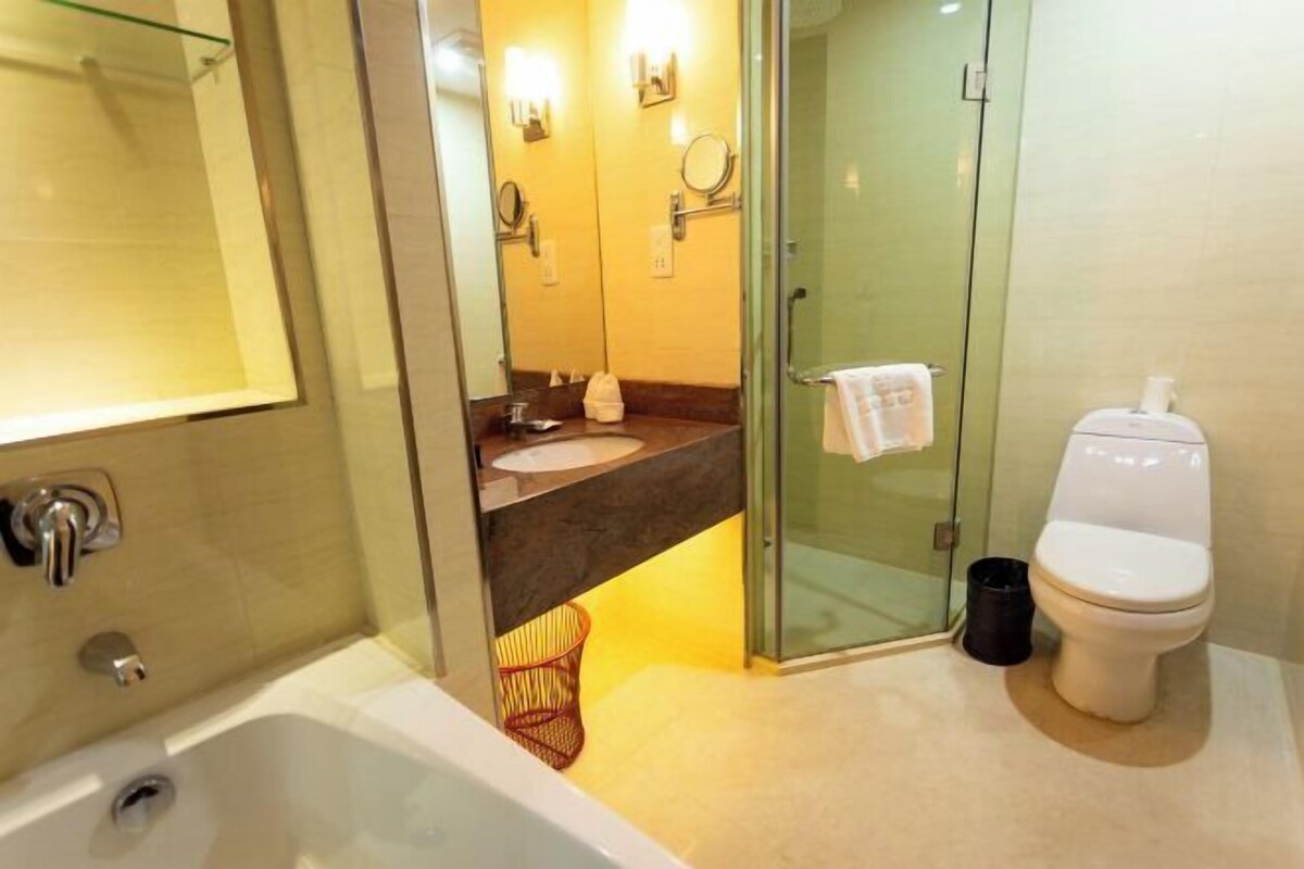 A bathroom with a bathtub, a sink, a toilet, and a glass shower enclosure.