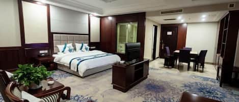 A hotel room with a bed, a TV, a desk, and a chair.