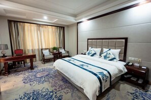 A hotel room with a large bed, a desk, a chair, and a nightstand. - Guoyuan Hotel (Taizhou)