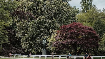 A park with a statue, benches, and a pond.
