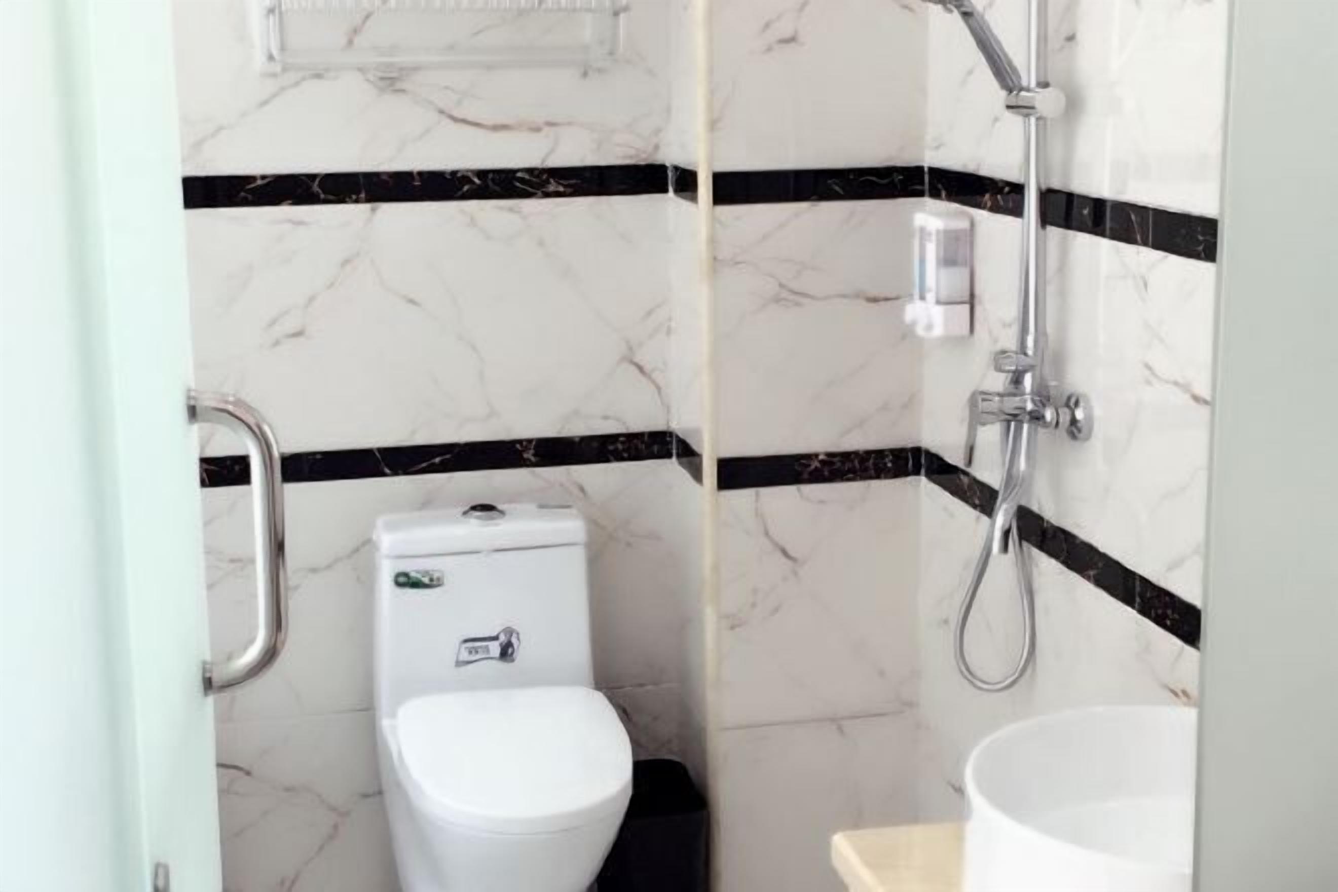 A bathroom with a toilet, a sink, and a shower.