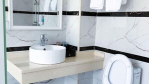 A bathroom with a white sink, a mirror, and a toilet. - Yan Nian Hotel (Baise)