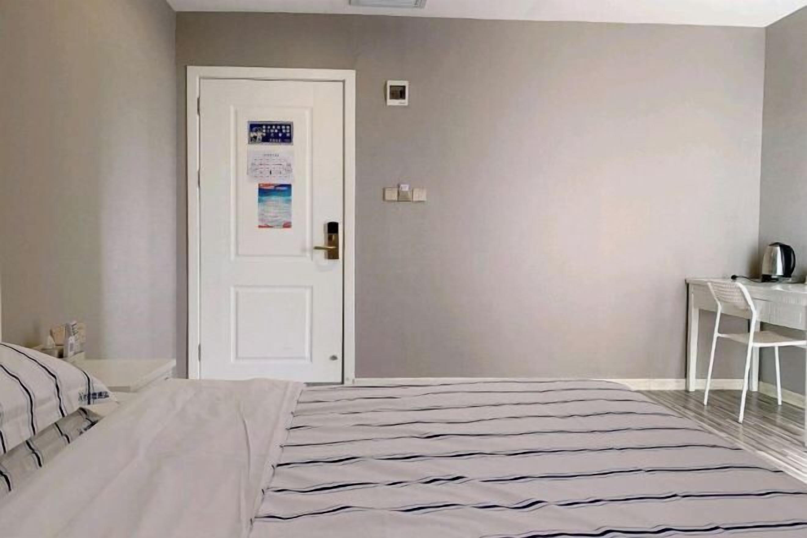 A hotel room with a bed, a desk, and a chair.