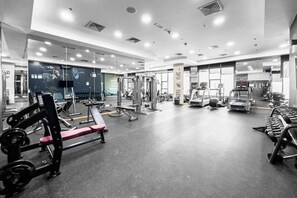 A modern gym with various exercise equipment, mirrors, and a clean, well-lit interior.