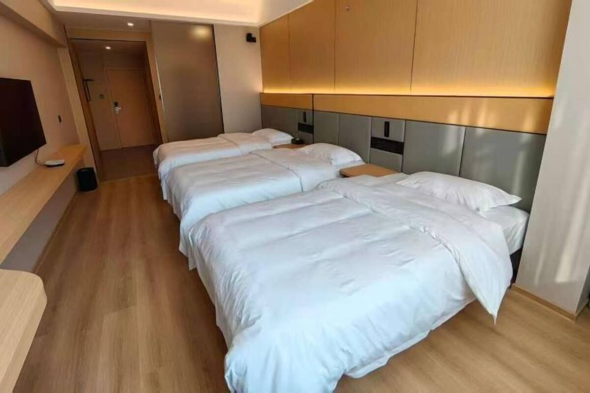 Een hotelkamer met een groot bed, een televisie en een houten vloer.