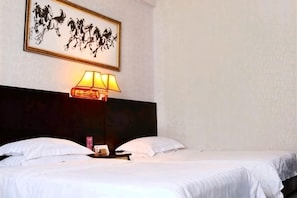 A hotel room with a bed, a nightstand, a lamp, and a framed artwork on the wall.