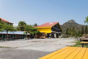 A building with a red roof, a yellow building in the background, and a mountain in the distance. - Kentting Dajenshan Chalet (Pingtung)