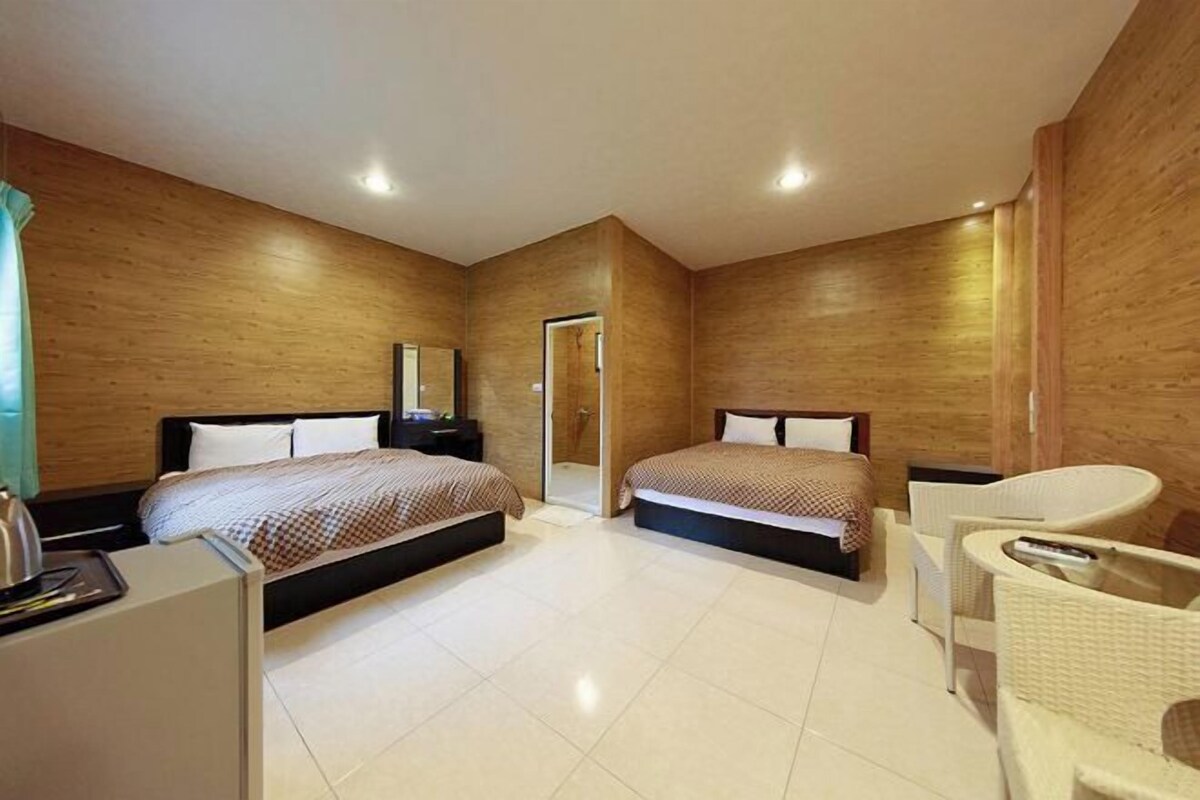 Una habitación de hotel moderna con dos camas, un escritorio, una silla y un baño.