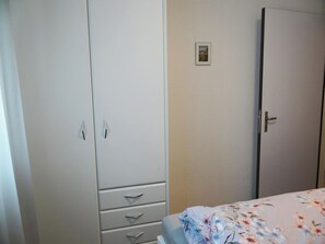 A bedroom with a bed, a wardrobe, and a door.