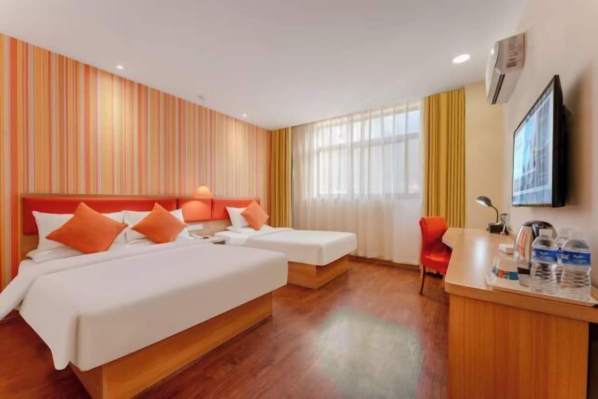 Une chambre d’hôtel avec deux lits, un bureau, une chaise et une télévision.
