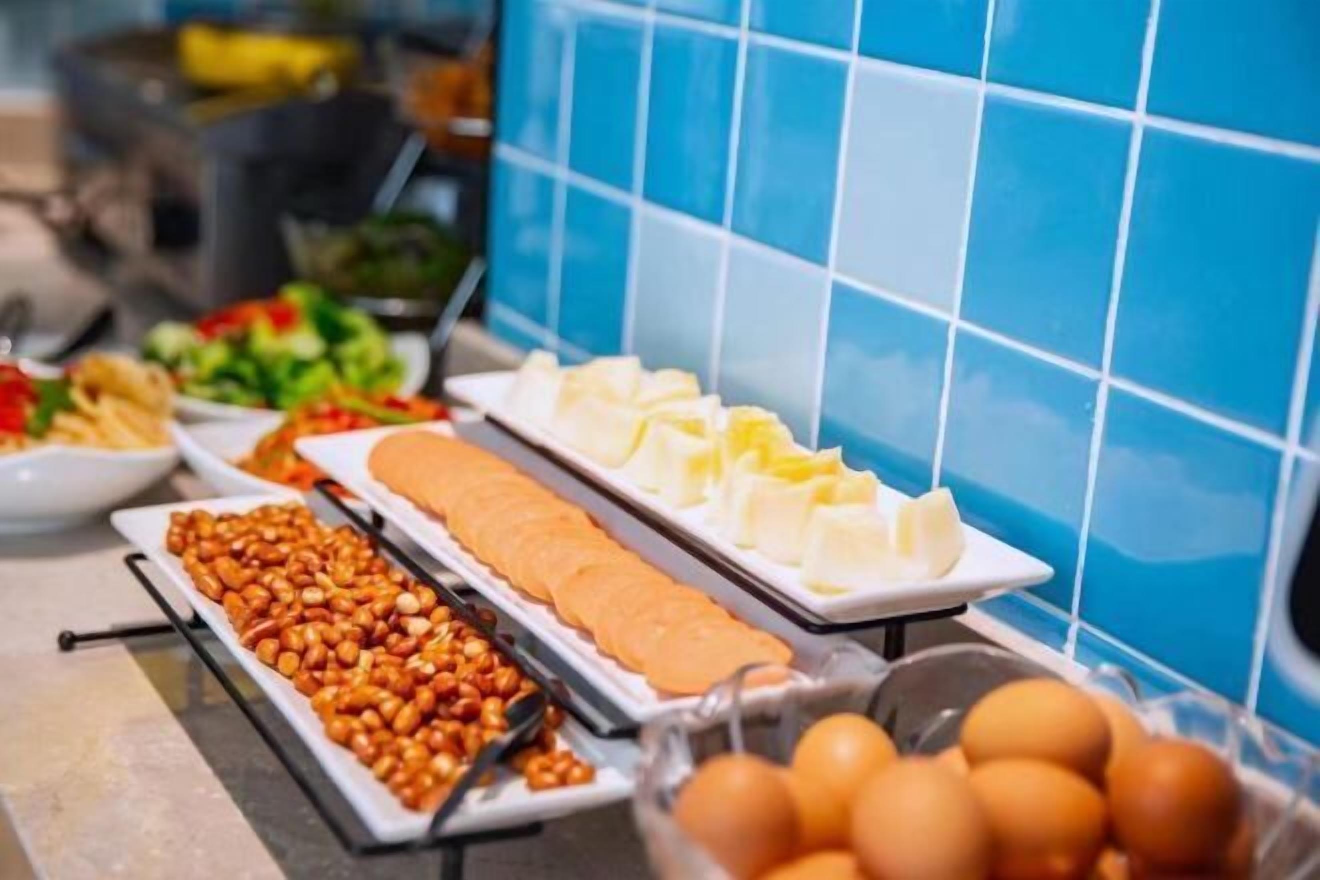 A buffet with various food items including sliced bread, cheese, and nuts.