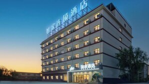 A multi-story hotel with a modern design, featuring a prominent sign at the top and a well-lit entrance. - Home Inn (Huayin Huashan Scenic Area Branch) (Huayin)