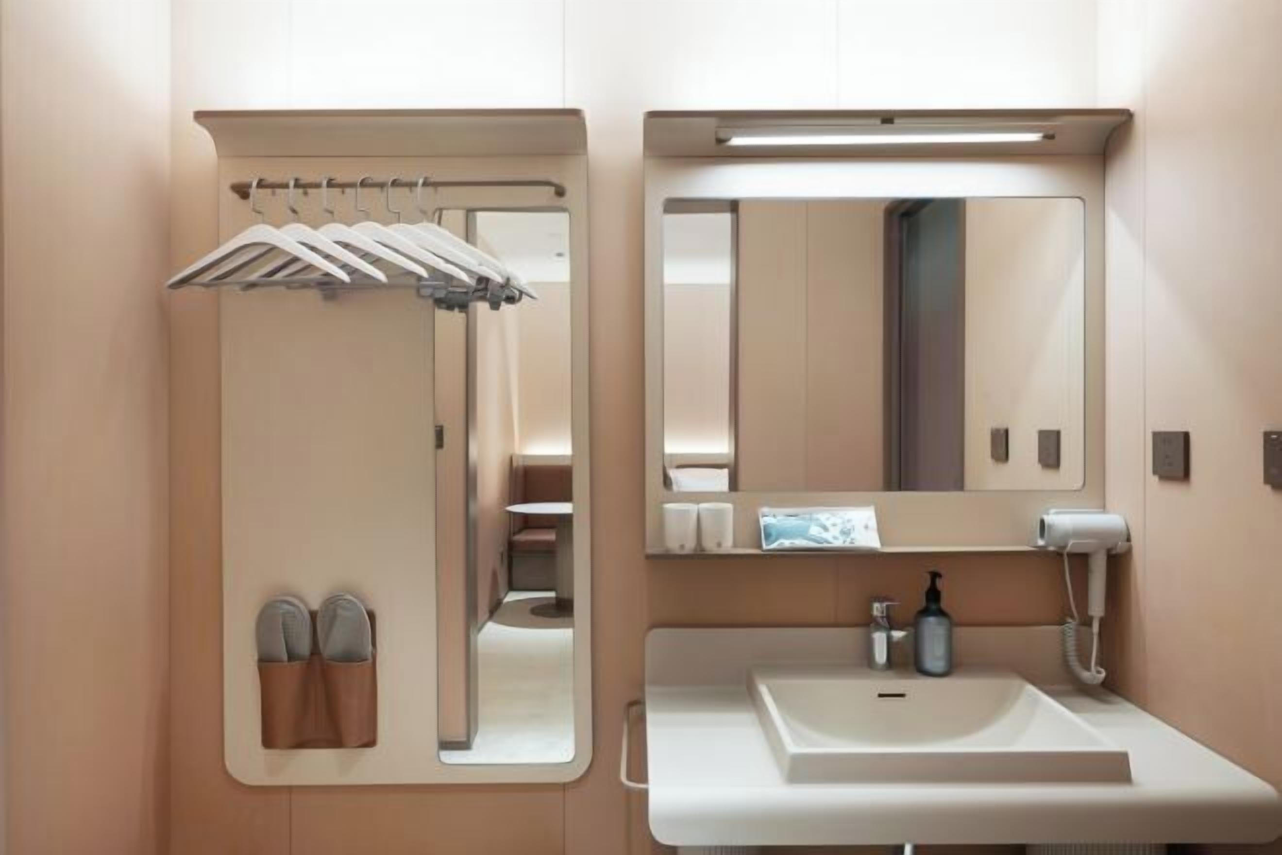 A modern bathroom with a built-in mirror, a sink, and a towel rack.