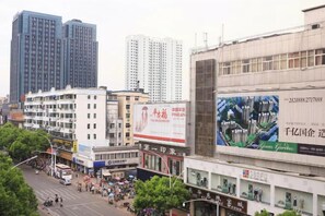 Une rue de la ville avec des immeubles, un autobus et des piétons.