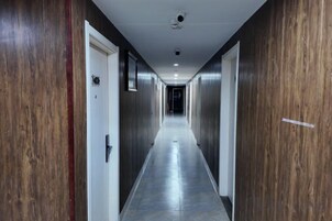 Un largo pasillo estrecho con paneles de madera en las paredes y suelo de baldosas.